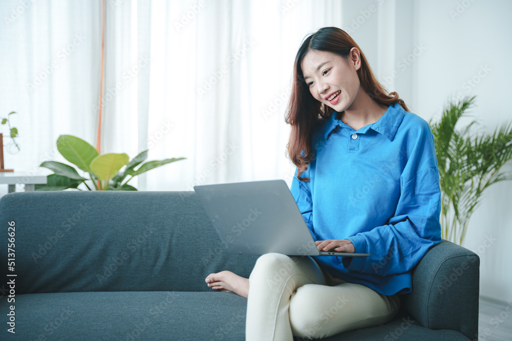 girl sitting on the sofa at home working on the computer. beautiful smile girl sitting on the sofa at home working on the computer. beautiful smile