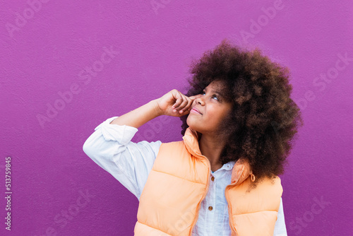 Girl with Afro hairstyle looking up against purple background