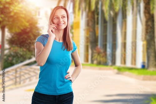 Fototapeta Naklejka Na Ścianę i Meble -  Young woman listening on her mobile phone walking outdoors