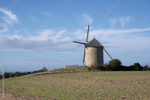 Windmill on a top of a hill with Mont Saint Michel in the backround, Normandy, France photo