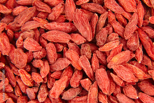 Dried goji berries red background top view