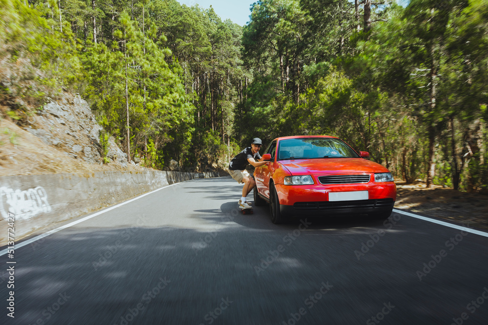 Young people Gen Z having fun skating in the forest, holding to a car