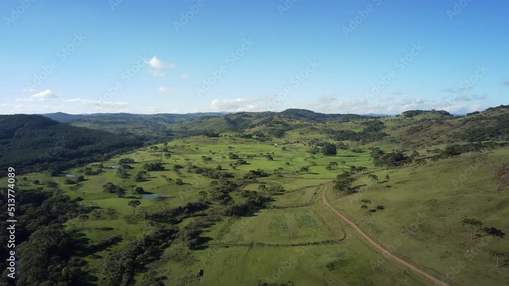 Gorgeous drone hyper-lapse of green valley under a colorful blue sky with some small and shy clouds starting to form in the horizon in the elapsed time. Gorgeous drone hyper-lapse of green valley under a colorful blue sky with some small and shy clouds starting to form in the horizon in the elapsed time.