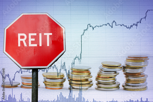 REIT sign on economy background with graph and coins. photo