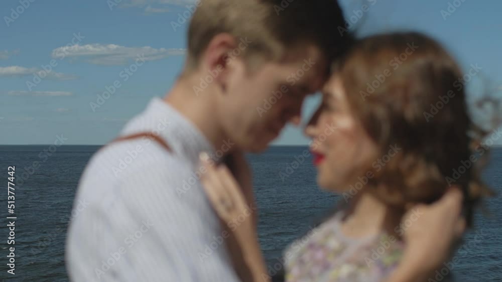 Refocus Couple in love hugs, blurred medium shot the couple stands opposite each other with their eyes closed, slow motion, the sea is in the background, the wind develops female hair. Refocus Couple in love hugs, blurred medium shot the couple stands opposite each other with their eyes closed, slow motion, the sea is in the background, the wind develops female hair.
