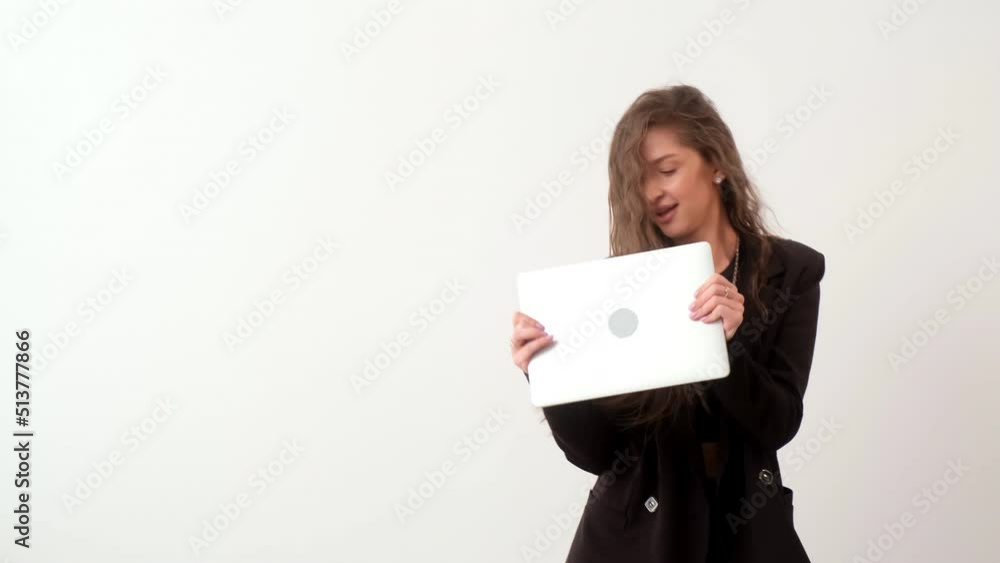 A happy businesswoman celebrates a successful deal or financial gain by dancing with her laptop. An excited smiling young woman rejoicing over profits or finances. The concept of a successful business A happy businesswoman celebrates a successful deal or financial gain by dancing with her laptop. An excited smiling young woman rejoicing over profits or finances. The concept of a successful business