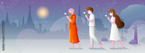 Buddhists walking with lighted candles in hand around a temple to pay respect and belief to religion