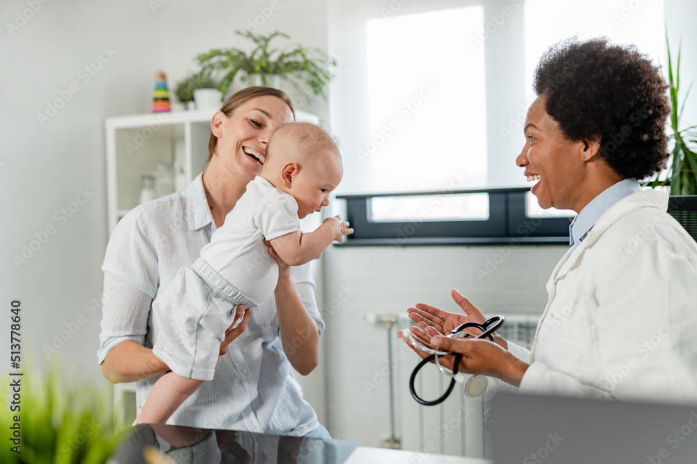 Fototapeta premium The consultant pediatrician with the baby patient and mother