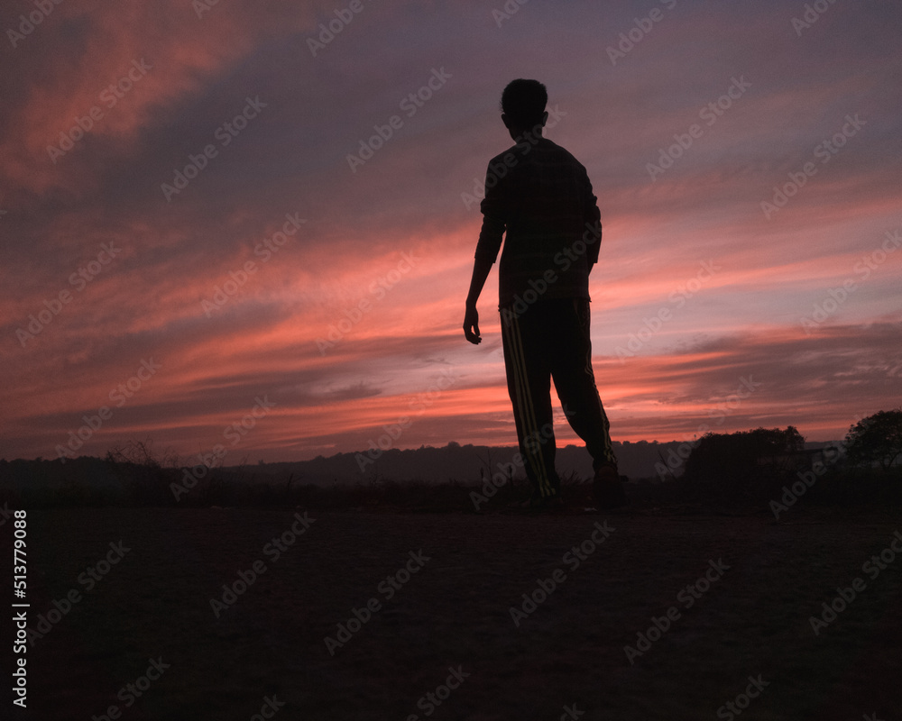 Fire sunset silhouette with man walking