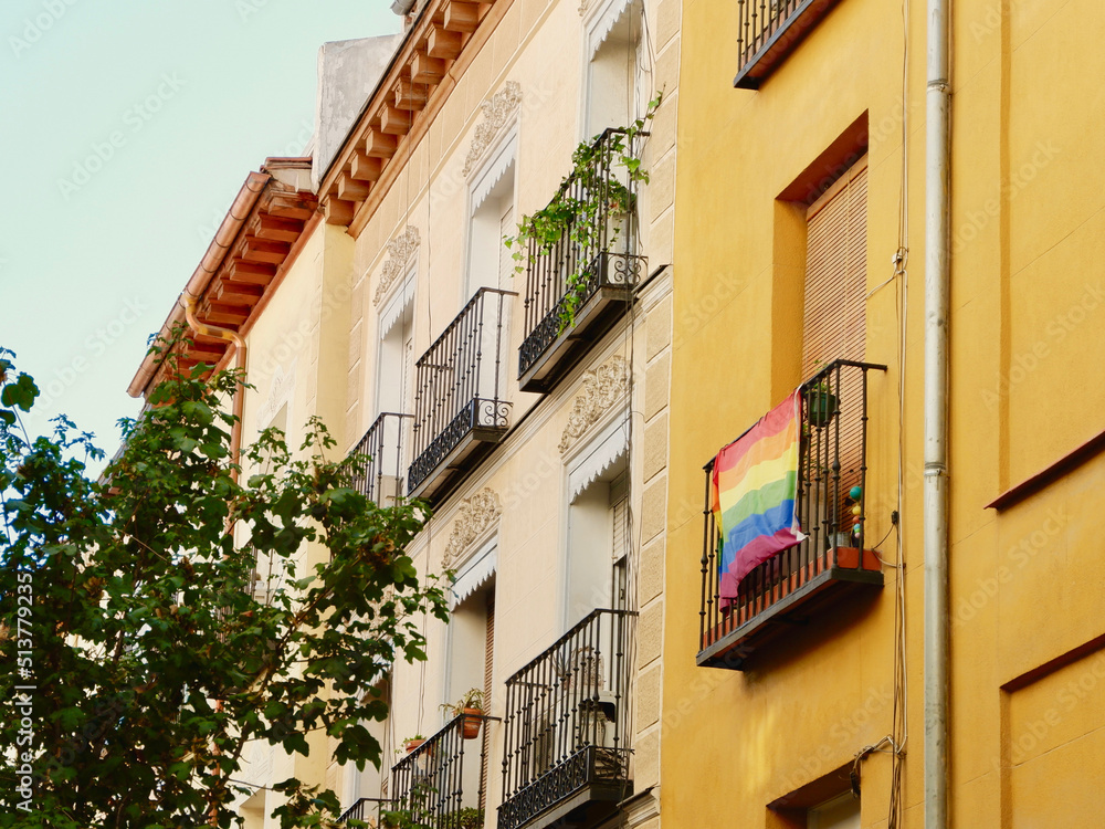Colourful buildings with rainbow flag of gay community on the balcony.  Symbol of support for LGBTQ people