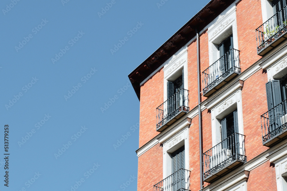 Corner of classical building made of red brick in downtown district of Madrid, Spain