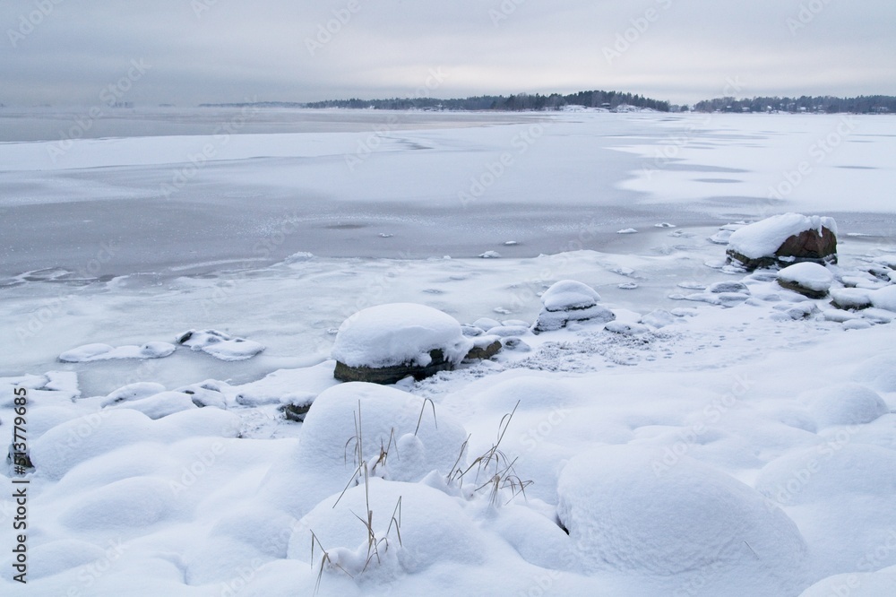 Ice covered rocks on the shore at Lauttasaari, Helsinki, Finland.
