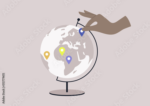 A round Globe on a metal stand with location pin stickers on it, educational and travel concept