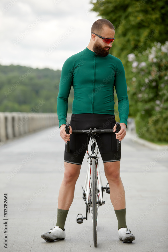 Fototapeta premium A cyclist in motion. Bike ride along the embankment along the river.