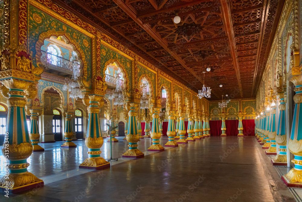 Mysore, Karnataka, India - November 25th 2018 : Beautiful decoated interior ceiling and pillars of the Ambavilasa Hall, inside the royal Mysore Palace. Gold used on gilded columns and glass ceiling.