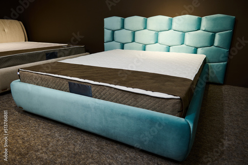 A comfortable modern stylish velour turquoise double beds with orthopedic hard mattresses, displayed for sale in the showroom of a furniture store