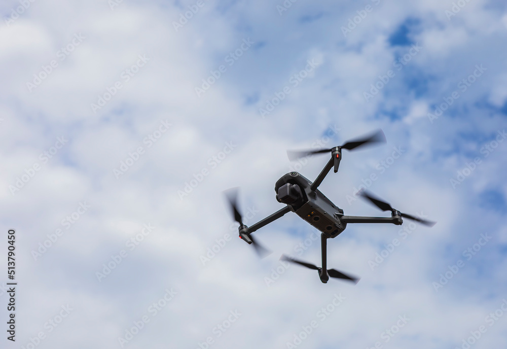 Flying drone on cloudy sky background Flying drone on cloudy sky background