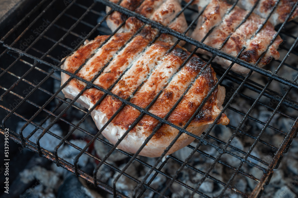 Grilling pork meat on the steel grid. Summer rest concept