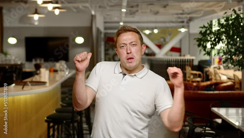 Happy business man showing thumb up, looking towards camera in office. Business owner happy and dancing, freaky type