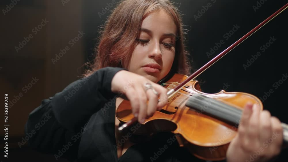 young chubby female violin player is performing music on scene in modern opera house young chubby female violin player is performing music on scene in modern opera house
