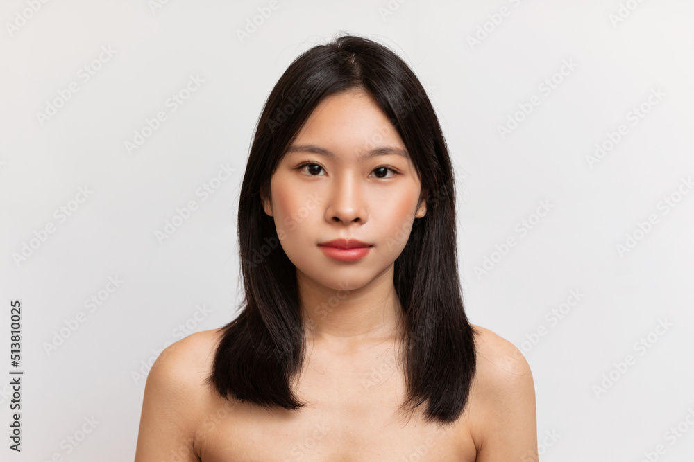 Beauty face. Portrait of japanese lady with natural makeup and healthy skin looking at camera over white background Beauty face. Portrait of japanese lady with natural makeup and healthy skin looking at camera over white background