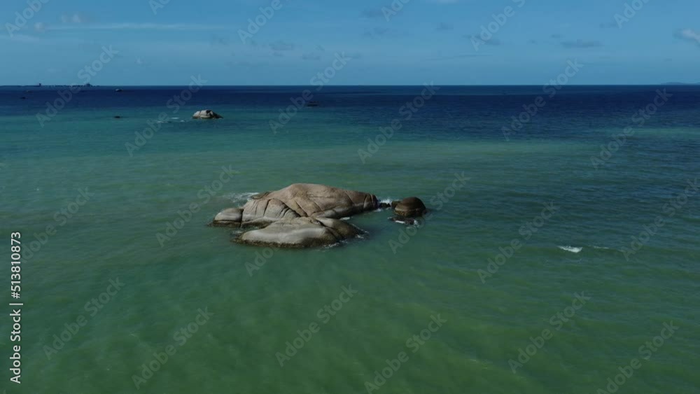 Seascape view of the ocean and little island rock with blue sky Seascape view of the ocean and little island rock with blue sky