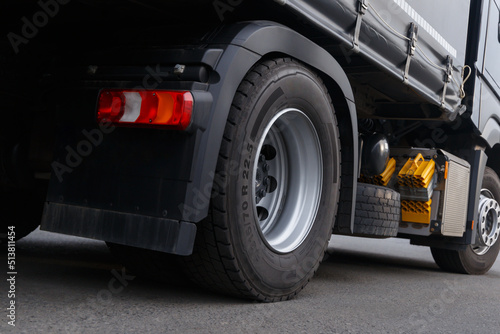 The concept of cargo transportation. Trucking Concept Photo. Modern appearance of the back of the truck. Semi Truck Rear Side Close up. Red brake lights and orange turn signals. Road safety.