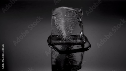 Melting ice cube. Cube starts spinning, rotating and leaves scene to background. 