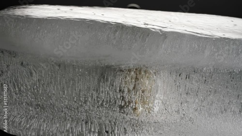 Melting ice cube sets head of Buddha free. Buddha head of stone is released by melt.