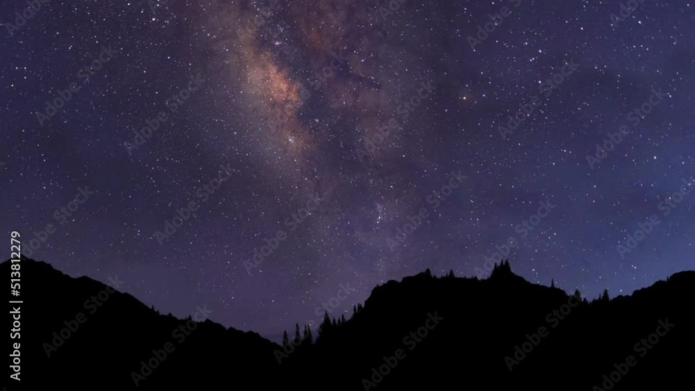 Night time lapse. The Milky Way Galaxy moving over the mountain ridge. Starry night background Night time lapse. The Milky Way Galaxy moving over the mountain ridge. Starry night background