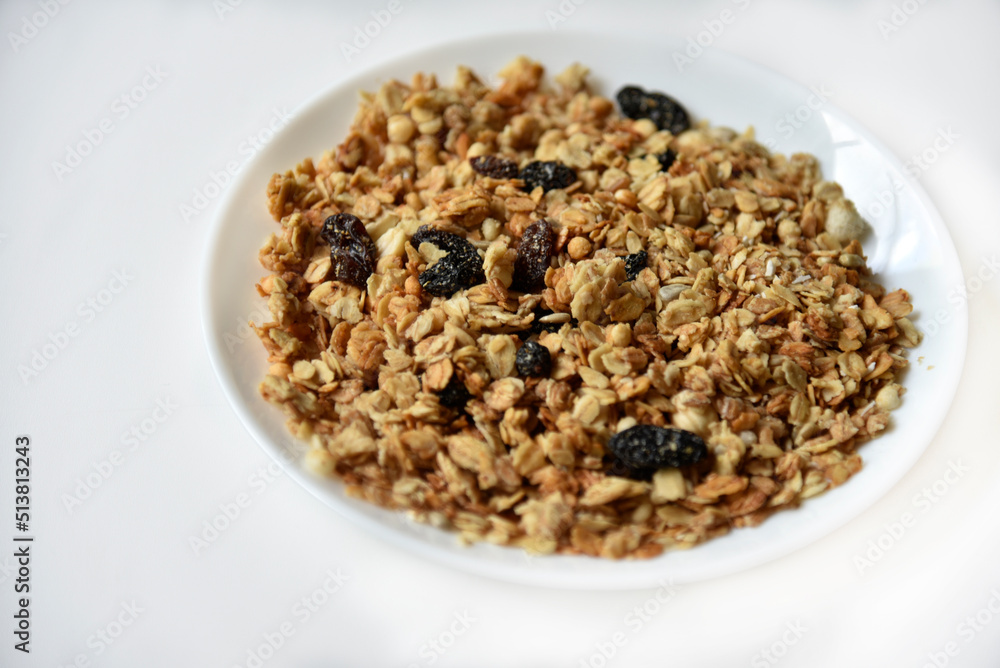 Muesli with nuts and raisins on a white plate Muesli with nuts and raisins on a white plate