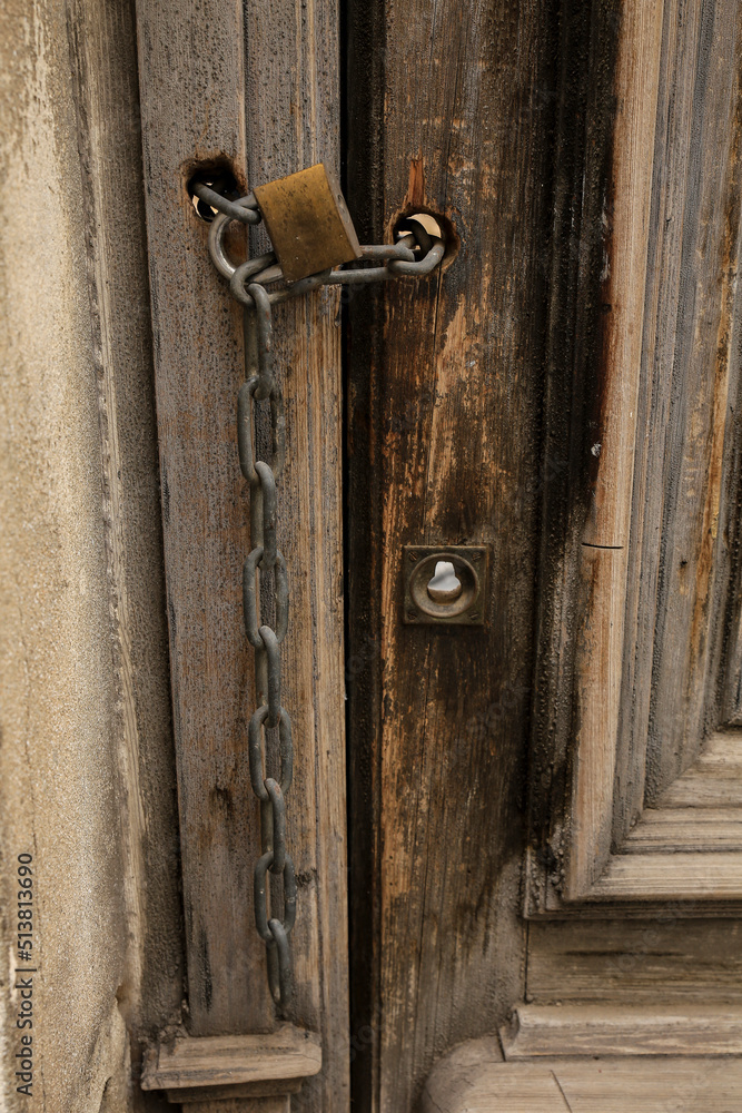 Old wooden door closed with chain and padlock Old wooden door closed with chain and padlock