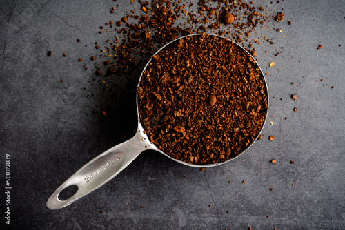 Canvas Print Coarsely Ground Coffee in a Measiring Cup: Freshly ground coffee overflowing a m