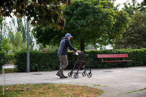 an older man walks with the help of a walker