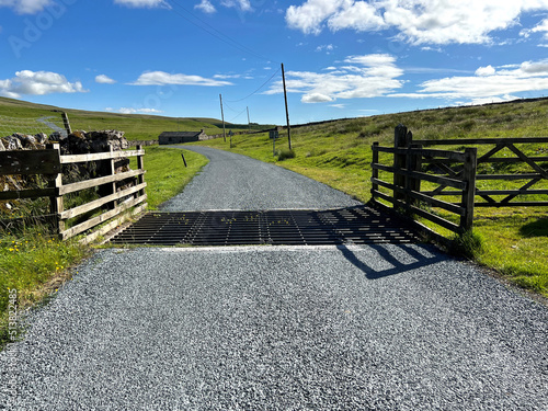 Cattle grid, high on the moors, with a farm building, and sunny weather near, Malham, Skipton, UK photo