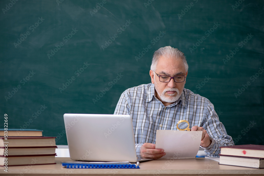 Old male teacher in the classroom Old male teacher in the classroom