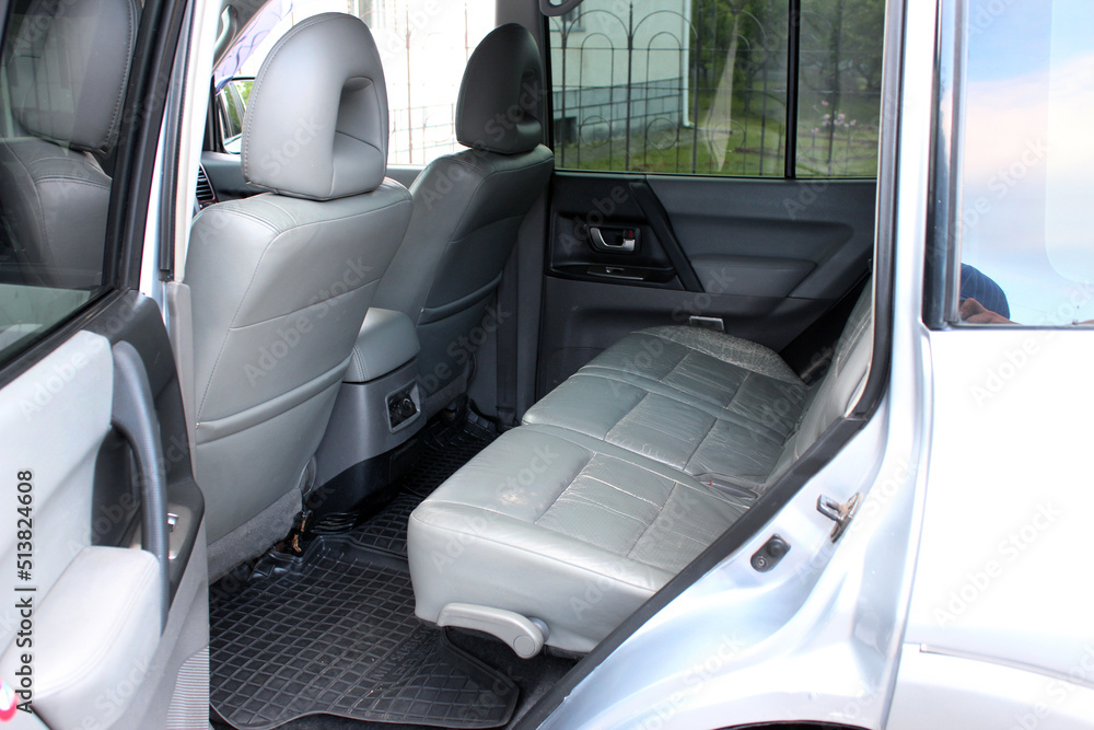Rear seats in modern SUV. Close-up on rear seats with grey leather in the interior. Interior details inside car. Light grey leather car seats.