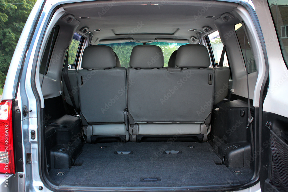 Open back door modern SUV. Clean, open empty trunk in the grey car. Rear view of the car open trunk. Opened empty car trunk.