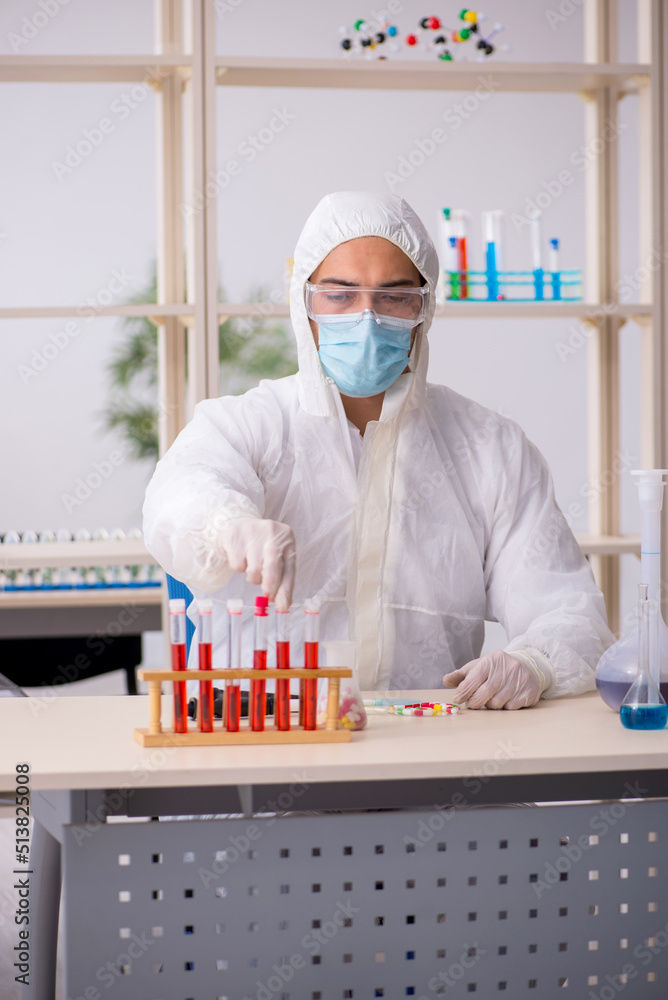 Young male chemist in drugs syntesis concept Young male chemist in drugs syntesis concept