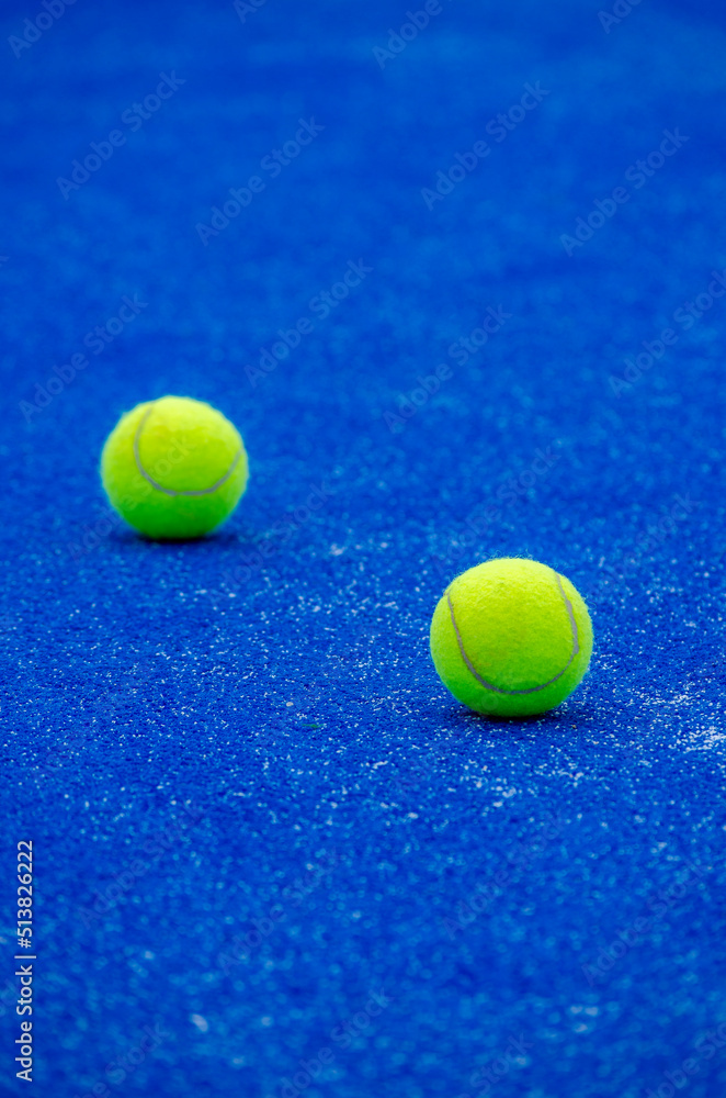 selective focus, two balls on a blue artificial grass paddle tennis court