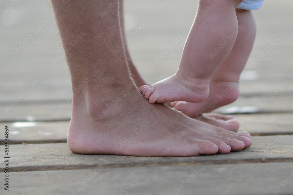 Newborn child standing on father's feet Newborn child standing on father's feet