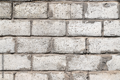 An old white wall made of rough ceramsite concrete blocks as a background photo