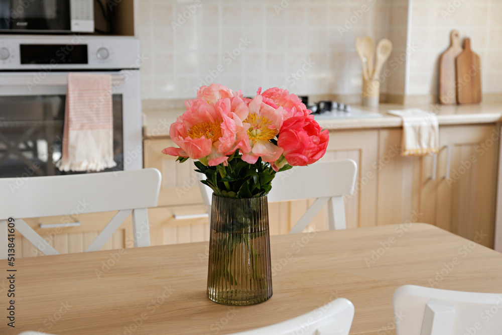 Vases with Beautiful Flowers on Table in Kitchen Interior. Stock