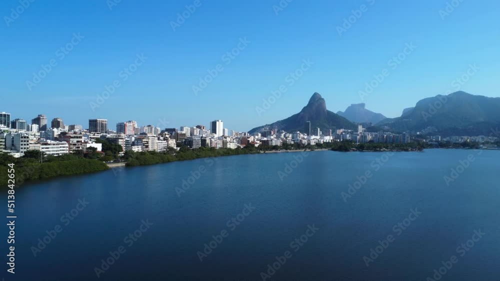 Aerial view of Rodrigo de Freitas Lagoon, south zone of Rio de Janeiro, Brazil. In the background, the beaches of Ipanema and Leblon and Morro Dois Irmãos. Sunny day. Buildings around. Drone take. Aerial view of Rodrigo de Freitas Lagoon, south zone of Rio de Janeiro, Brazil. In the background, the beaches of Ipanema and Leblon and Morro Dois Irmãos. Sunny day. Buildings around. Drone take.