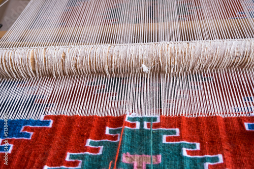Detail of loom for weaving traditional handmade carpets, rugs.  Weaving and manufacturing of Turkish style homemade carpets. Selective focus.