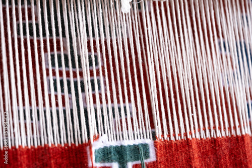 Close up, Detail of loom for weaving traditional handmade carpets, rugs.  Weaving and manufacturing of Turkish style homemade carpets. Selective focus.