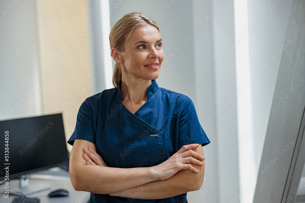 Portrait of doctor in uniform standing with crossing hands and looking away . High quality photo Portrait of doctor in uniform standing with crossing hands and looking away . High quality photo