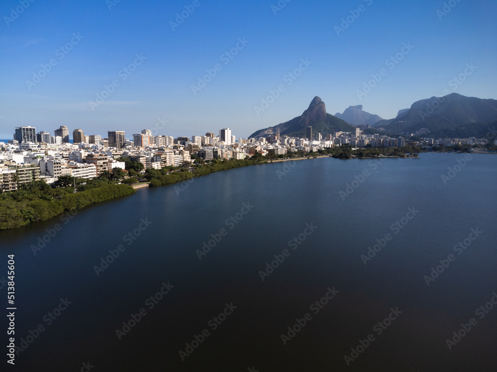 Fototapeta premium Aerial view of Rodrigo de Freitas Lagoon, south zone of Rio de Janeiro, Brazil. In the background, the beaches of Ipanema and Leblon and Morro Dois Irmãos. Sunny day. Buildings around. Drone photo
