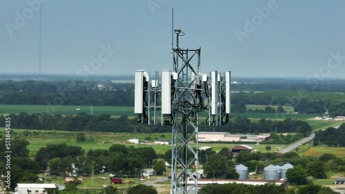 Close up aerial shot orbiting around a cell phone tower with safety light flashing.