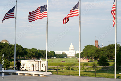 Anerican flags and Whashington monument against sky at sunset, capitol building in second ground